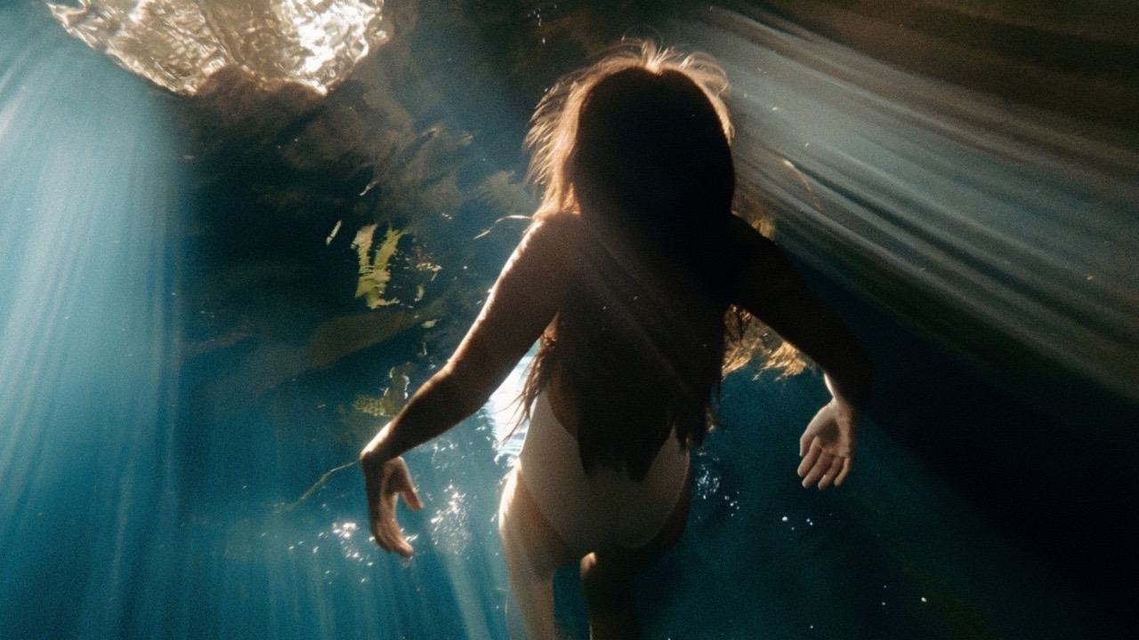 A swimmer beneath shafts of light, photographed by Alejandro Iturralde